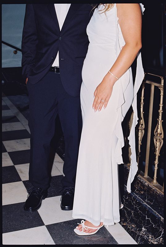 Juan David and Hannah standing side by side on a checkerboard marble floor