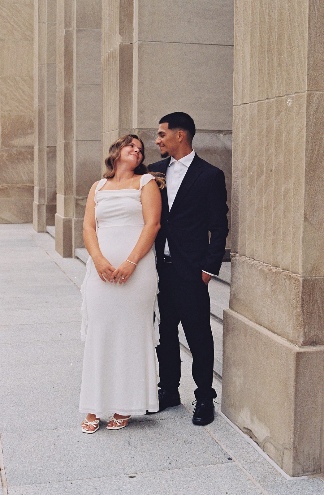 Juan David smiling at Hannah as they stand among stone columns